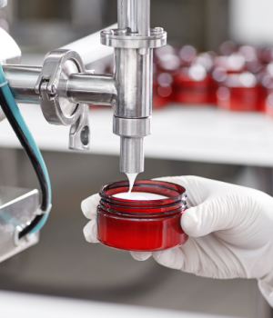 worker-filling-container-with-cream-cosmetic-factory